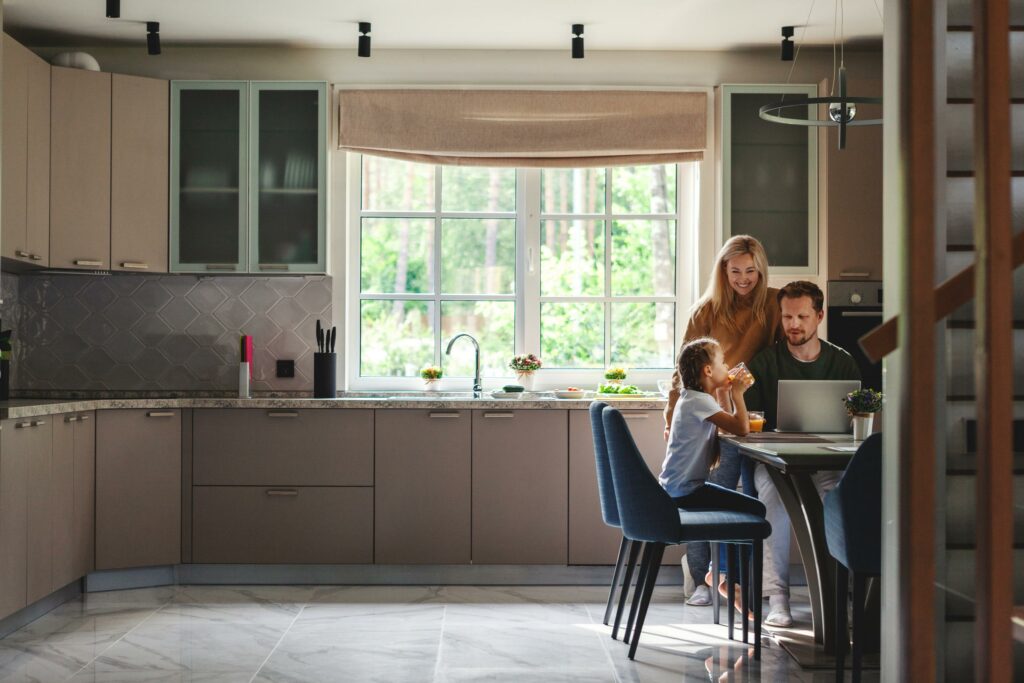 Man-woman-young-girl-in-kitchen-using-laptop