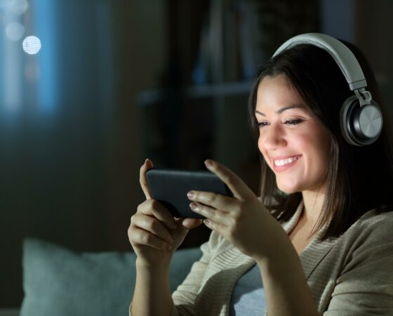 smiling-woman-with-headphones-watches-tv