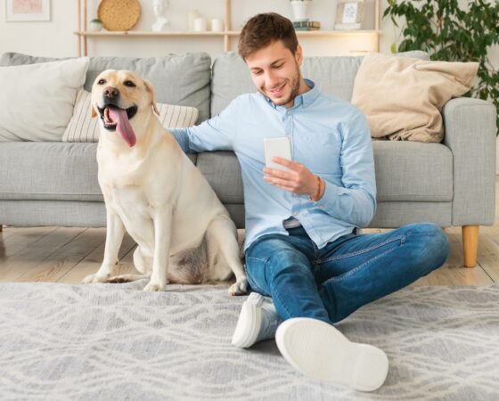 young-man-with-dog-using-mobile-phone