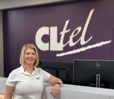 Employee standing at reception desk of CLTel office