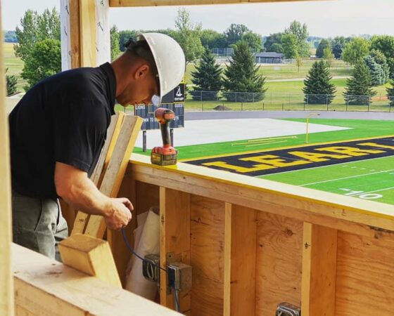 Technician installs fiber optic internet at Lions field stadium