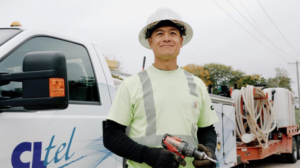 Telecommunications construction technician holding power drill outdoors