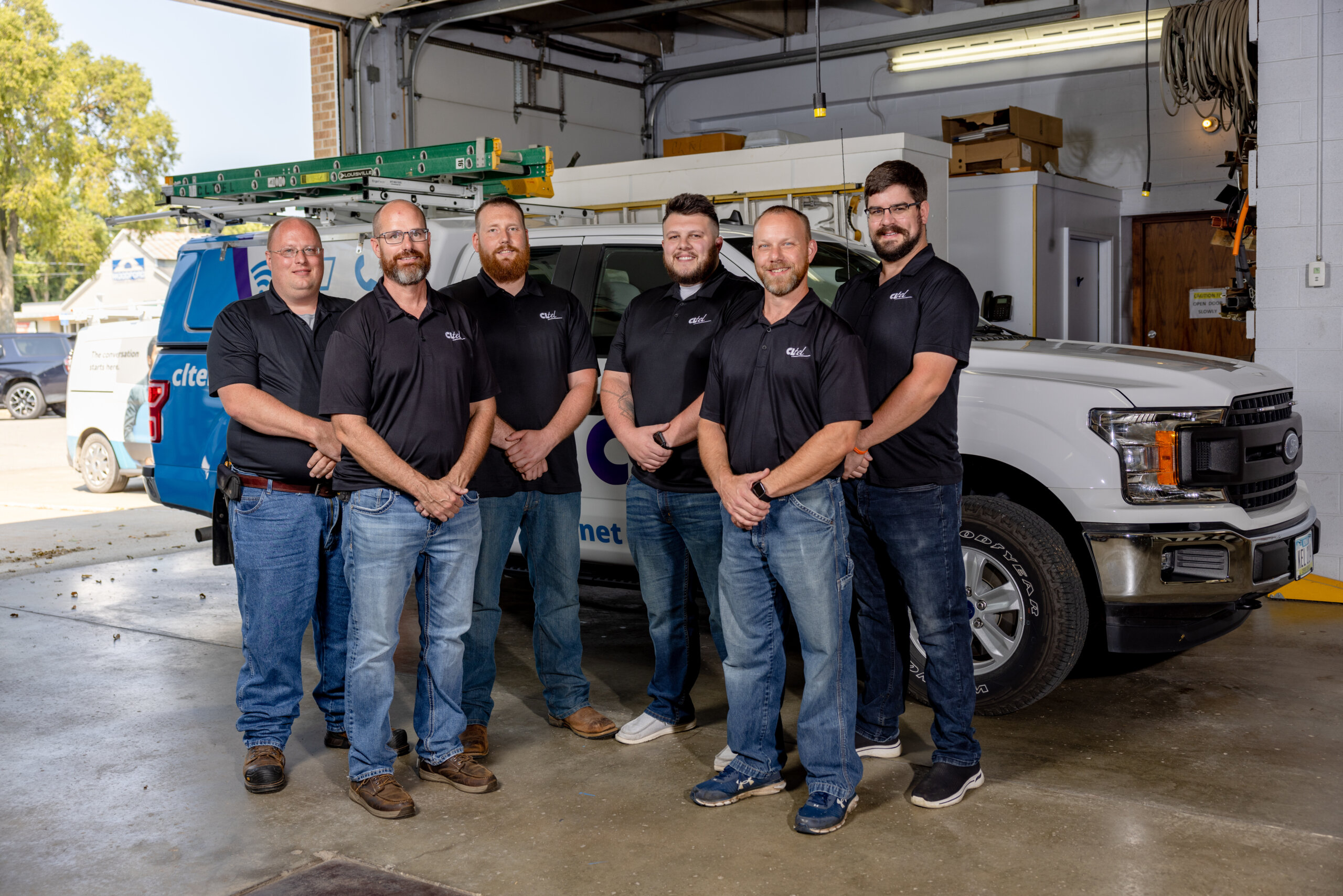 CL Tel technicians standing in garage.